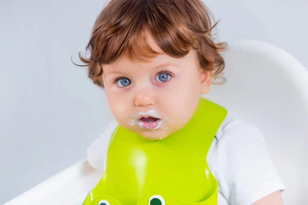 baby spitting up clear liquid hours after eating